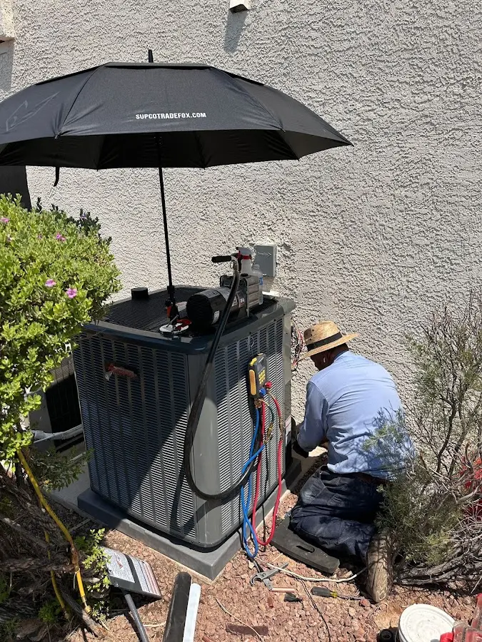 HVAC technician performing outdoor AC maintenance in Lee